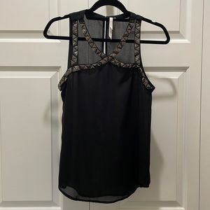 Black tank top with neckline cutouts and faux gemstone detailing